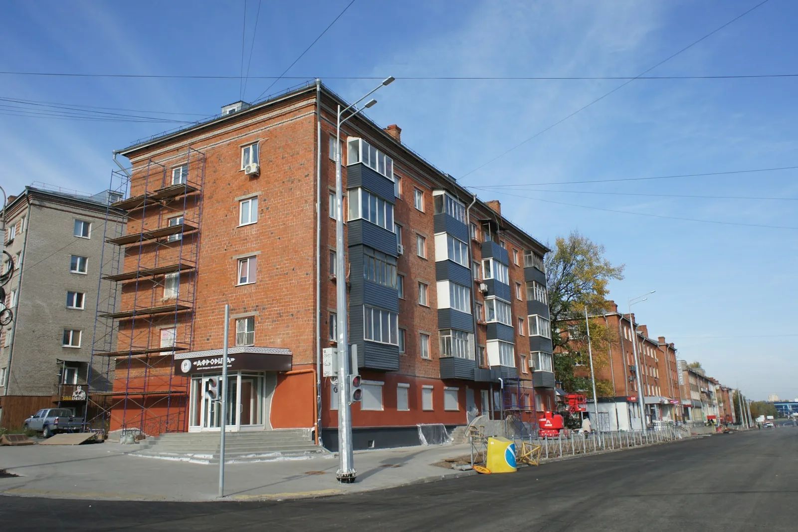 Backstein-Mehrfamilienhaus mit Gerüst an der Straßenfront